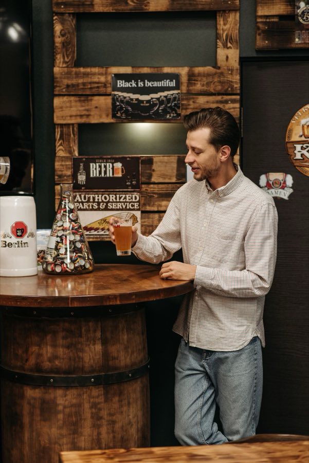 Gast mit Bierglas am Fasstisch
