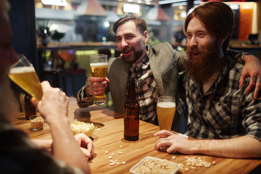 Freunde bei Bier und Snacks am Kneipentisch
